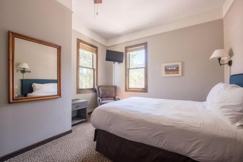 a bedroom with a bed and a mirror and a chair at Elk Mountain Lodge in Crested Butte