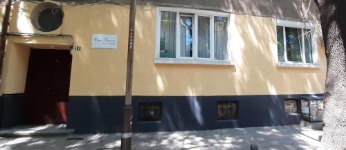 um edifício amarelo e azul com uma porta e janelas em Casa Ferrari Bed & Breakfast em Sófia