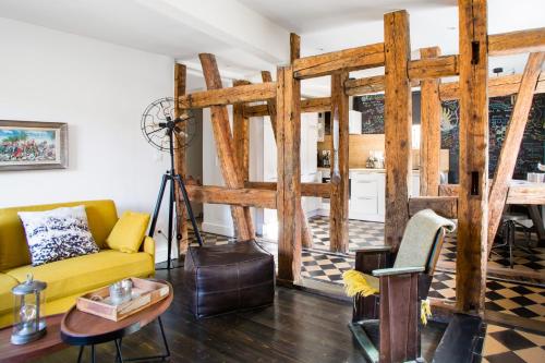 uma sala de estar com um sofá amarelo e uma mesa em Reflets Sur La Lauch appartements em Colmar