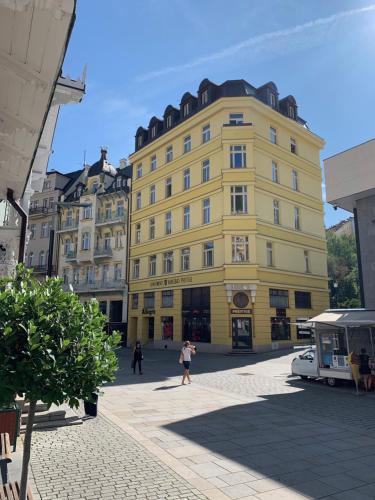 um edifício amarelo no meio de uma rua em Karlsbad Prestige em Karlovy Vary