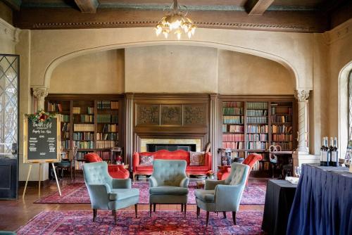 een bibliotheek met stoelen, een tafel en boekenplanken bij Berkeley City Club Hotel in Berkeley