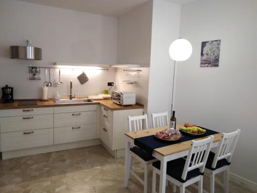 a small kitchen with a table and chairs and a sink at Casa Pallamaio Historic Center Vicenza in Vicenza