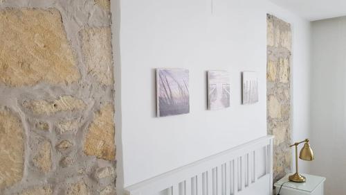 ein weißer Flur mit drei Bildern an der Wand in der Unterkunft Windstill Apartments in Rust