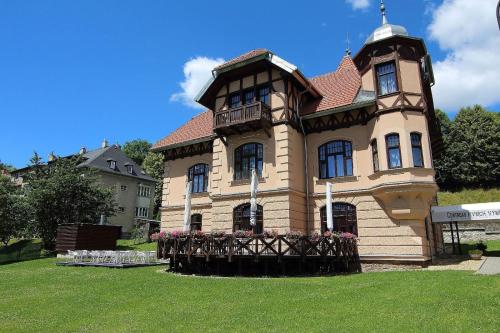 una casa grande con flores delante en Vila ELIS, en Jeseník