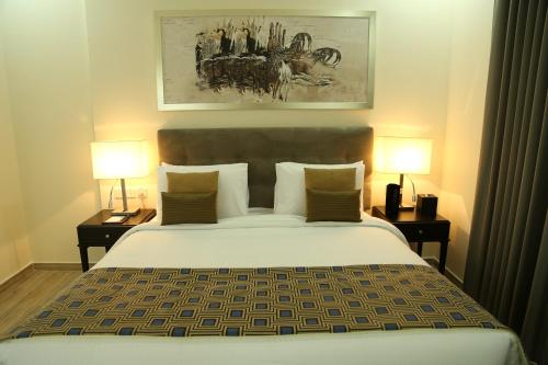 A bed or beds in a room at Uptown Hotel Apartment Fujairah By Gewan