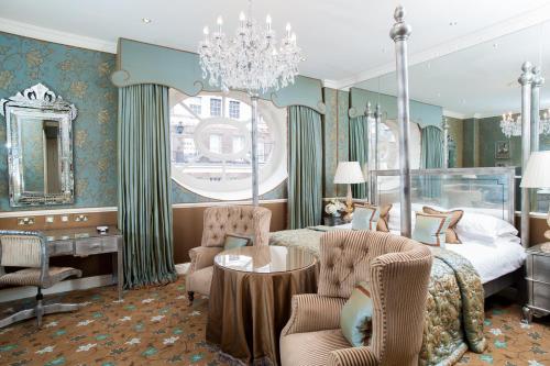 Schlafzimmer mit einem Bett, einem Tisch und Stühlen in der Unterkunft The Chesterfield Mayfair in London