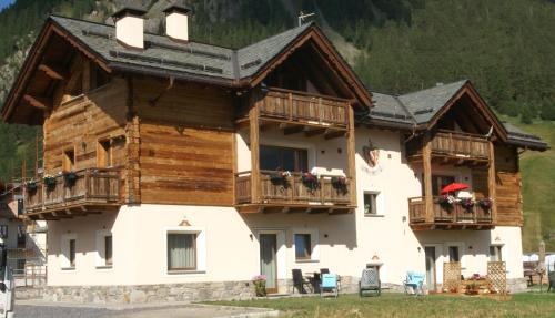 a large wooden house with balconies and tables and chairs at Al bait da Valeriano - Appartamento DaMì in Livigno