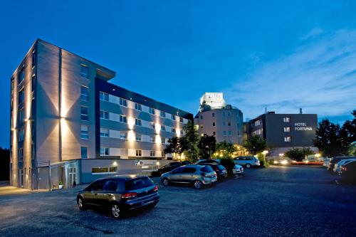 un parking avec des voitures garées devant un bâtiment dans l'établissement Hotel Fortuna Reutlingen-Tübingen, à Reutlingen