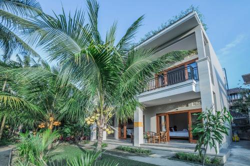 una casa con palme di fronte di Jero Griya Ubud ad Ubud