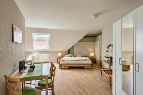 ein Schlafzimmer mit einem Bett und einem Tisch sowie ein Esszimmer in der Unterkunft Ferienwohnungen "Am Waidweg" in Bad Langensalza