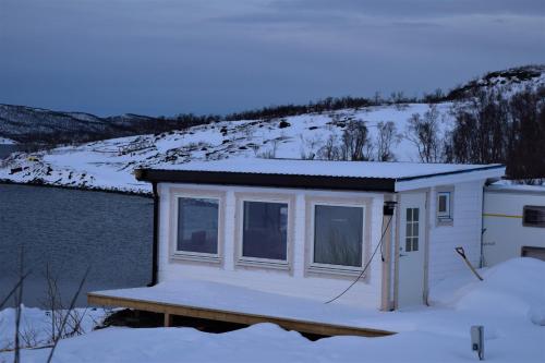 a tiny house on a dock in the snow at Captains Small House in Hamneide