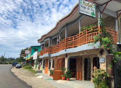 a building with a balcony on the side of a street at Hotel Hoja de Oro Corcovado in Puerto Jiménez