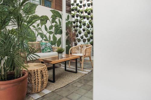 eine Terrasse mit Pflanzen, einem Tisch und Stühlen in der Unterkunft Adhisthana Hotel Yogyakarta in Yogyakarta