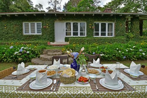 een tafel met borden eten voor een huis bij SaffronStays Nandanvan Estate, Kodaikanal in Kodaikānāl