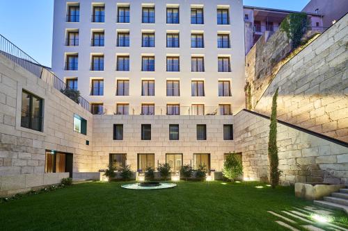 un gran edificio con césped delante en PortoBay Flores, en Oporto