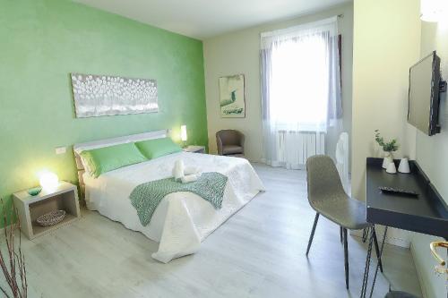 - une chambre avec un lit aux murs verts et un bureau dans l'établissement B&B Ulivo Gaio, à San Miniato