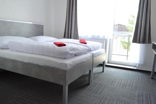 een bed met witte lakens en rode kussens erop bij Garni Hotel 31 in Spišská Nová Ves