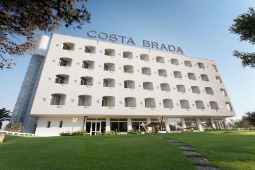 um grande edifício branco com um cartaz em Grand Hotel Costa Brada em Gallipoli