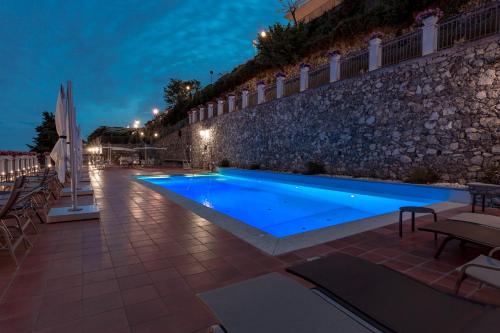 uma piscina em frente a um edifício à noite em Villa Piedimonte em Ravello