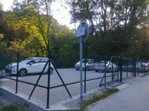 una señal de parada frente a una valla con coches aparcados en Hotel garni Paleta, en Škofja Loka