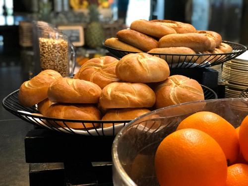 twee manden gevuld met donuts en sinaasappels op een toonbank bij Fletcher Parkhotel Val Monte in Berg en Dal