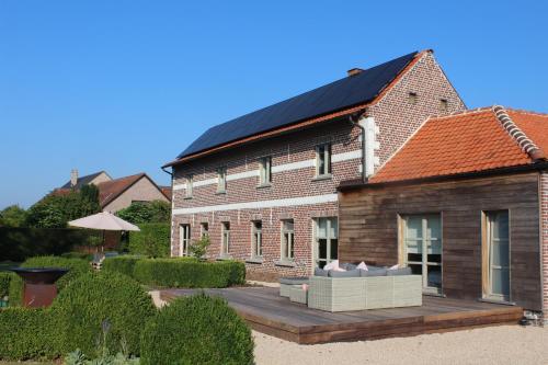 een huis met een zonnedak op een houten terras bij Mille Étoiles in Moorsel