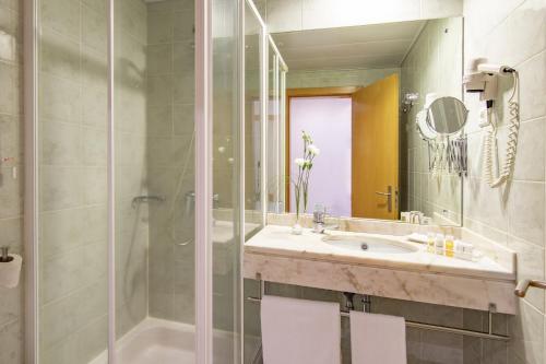 a bathroom with a sink and a shower at Luna Esperanca Centro Hotel in Setúbal