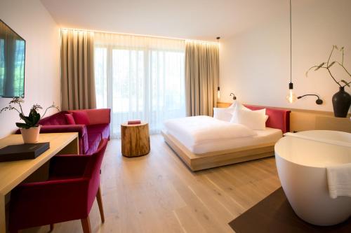 une chambre d'hôtel avec un lit et un canapé dans l'établissement Minglers Sportalm - Das Gourmet- und Genießerhotel, à Kirchberg in Tirol