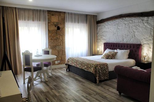 una camera con letto, tavolo e divano di Art'Otel Barcelos a Barcelos