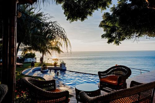 a view of a pool with chairs and the ocean at Hotel Vistalmar in Manta