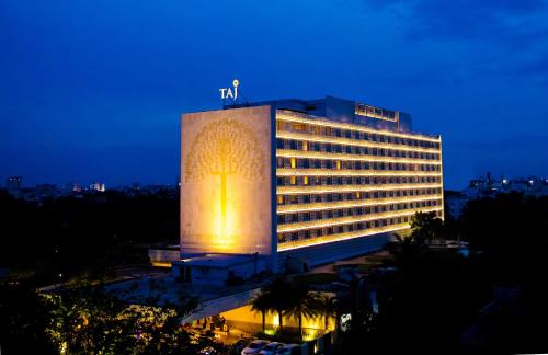 ein großes Gebäude mit beleuchteter Fassade in der Nacht in der Unterkunft Taj Coromandel in Chennai