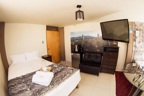 ein Hotelzimmer mit einem Bett und einem Flachbild-TV in der Unterkunft Sillary Hostal Boutique in Arequipa