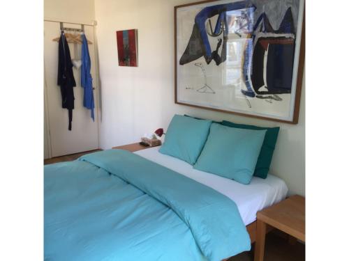 een slaapkamer met een bed met blauwe kussens bij Bed & Breakfast Leonie in Den Haag