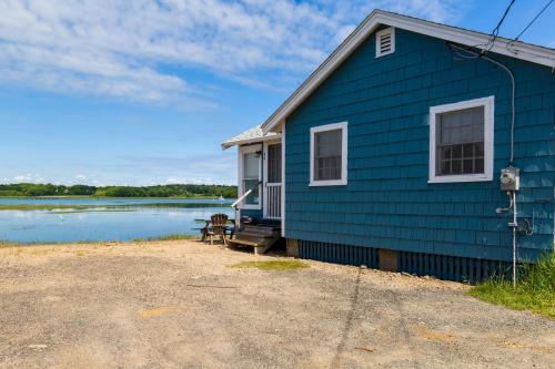 een blauw huis met een bank naast een meer bij The Eastern Avenue Cottage in Wells Beach