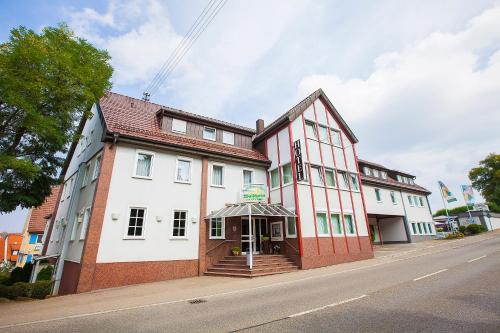 um edifício vermelho e branco ao lado de uma rua em Hotel Waldhorn em Böblingen