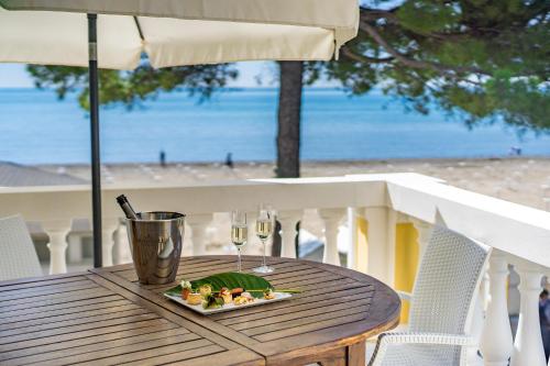 une assiette de nourriture sur une table sur la plage dans l'établissement Hotel Ville Bianchi, à Grado