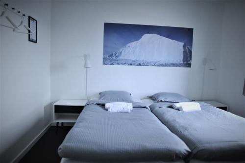 Nuuk City Hostel في نوك: سريرين توأم في غرفة مع صورة على الحائط