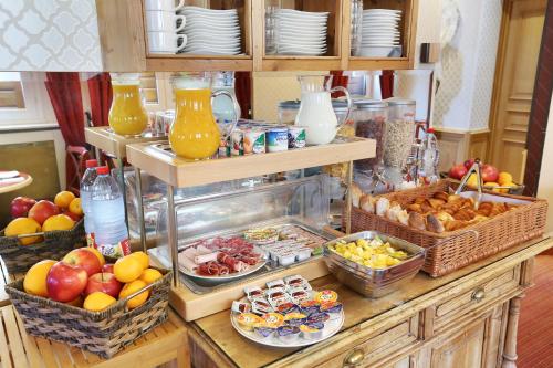 um buffet com muitas cestas de frutas e outros alimentos em Hotel du College de France em Paris