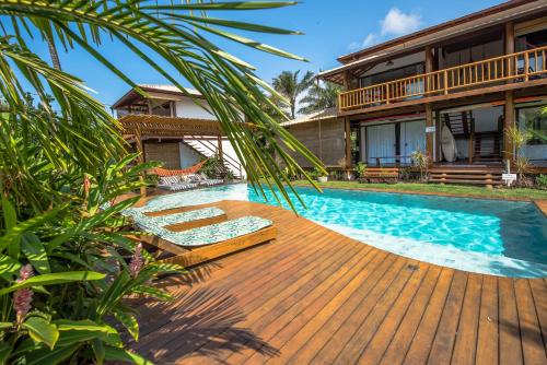 ein Haus mit einer Holzterrasse und einem Pool in der Unterkunft Sup House Barra Grande in Barra Grande