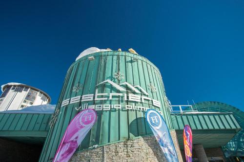 a green building with snowboards in front of it at TH Sestriere - Villaggio Olimpico in Sestriere