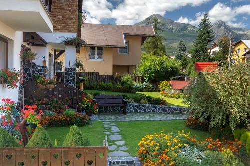 ein Haus mit einem Garten mit Blumen im Hof in der Unterkunft ASPEN in Nová Lesná