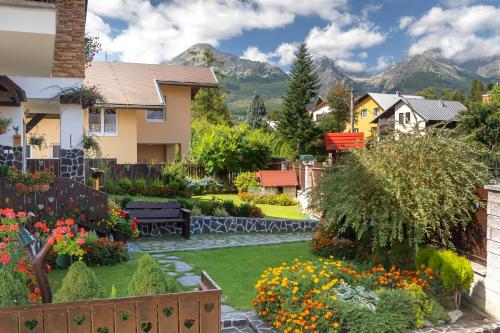 einen Hinterhof mit einem Garten mit Blumen und einem Haus in der Unterkunft ASPEN in Nová Lesná