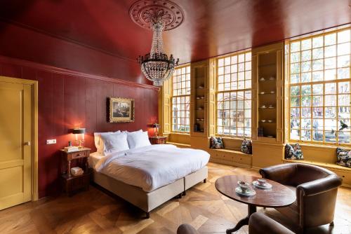 a bedroom with a bed and a table and a chandelier at Hotel Beijers in Utrecht