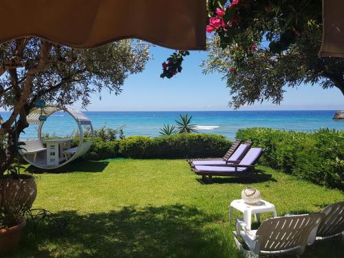 un cortile con due sedie, un'altalena e l'oceano di Corfu Glyfada Beach Apartment 13 a Glifada (Glyfada)