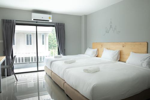 - une chambre avec 2 lits et une grande fenêtre dans l'établissement Fine Bed Hotel, à Nonthaburi