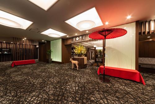 um hall de entrada com um guarda-chuva vermelho e um cão dentro em HOTEL Mai Sakura em Nara