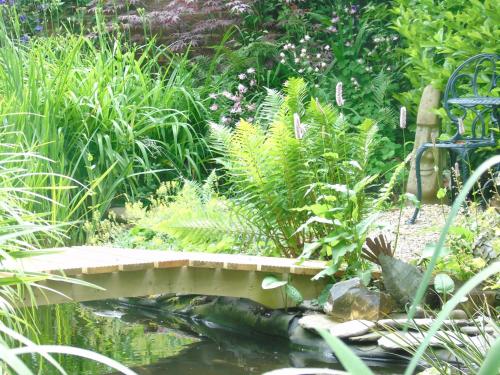 een brug over een vijver in een tuin bij The Old School B&B in Chichester