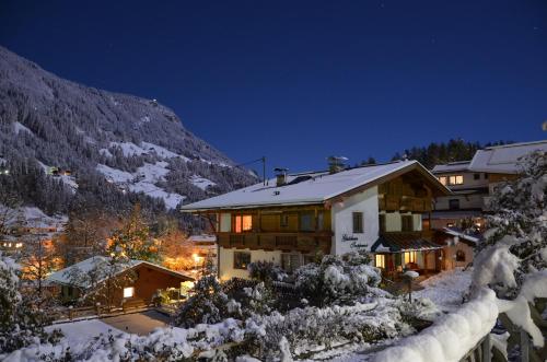 a house in the snow at night at Gästehaus Troppmair in Finkenberg