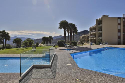 una piscina con palmeras y un edificio en Centro Cadro Panoramica, en Lugano