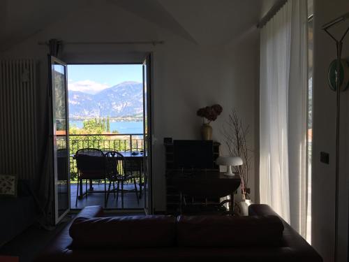 ein Wohnzimmer mit Sofa und Blick auf einen Balkon in der Unterkunft VILLA AS Campo Marzio in Lenno